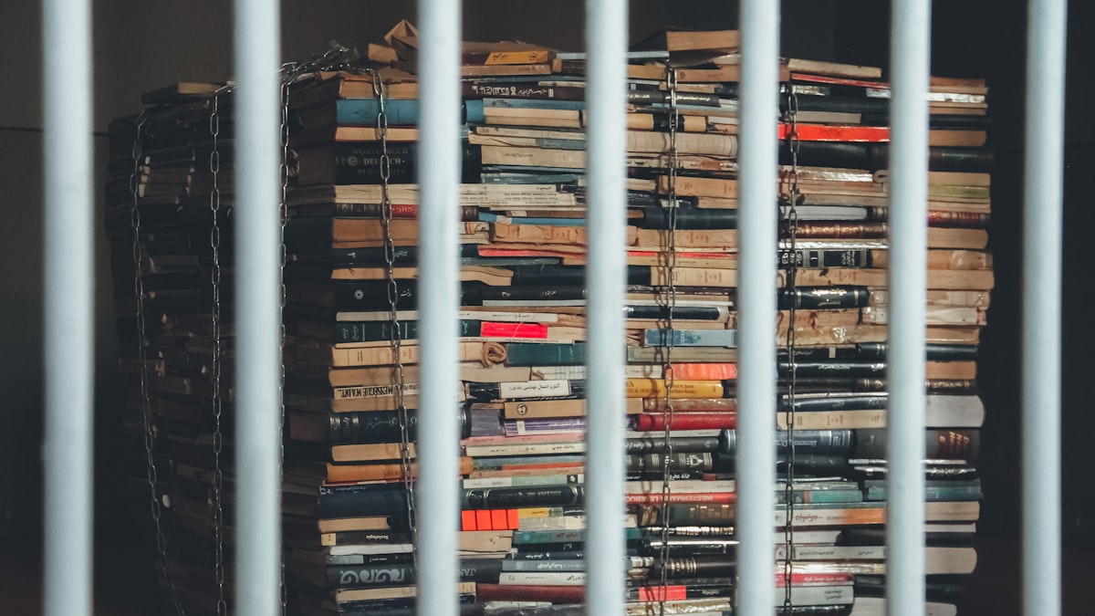 Preso consultando livros em biblioteca prisional