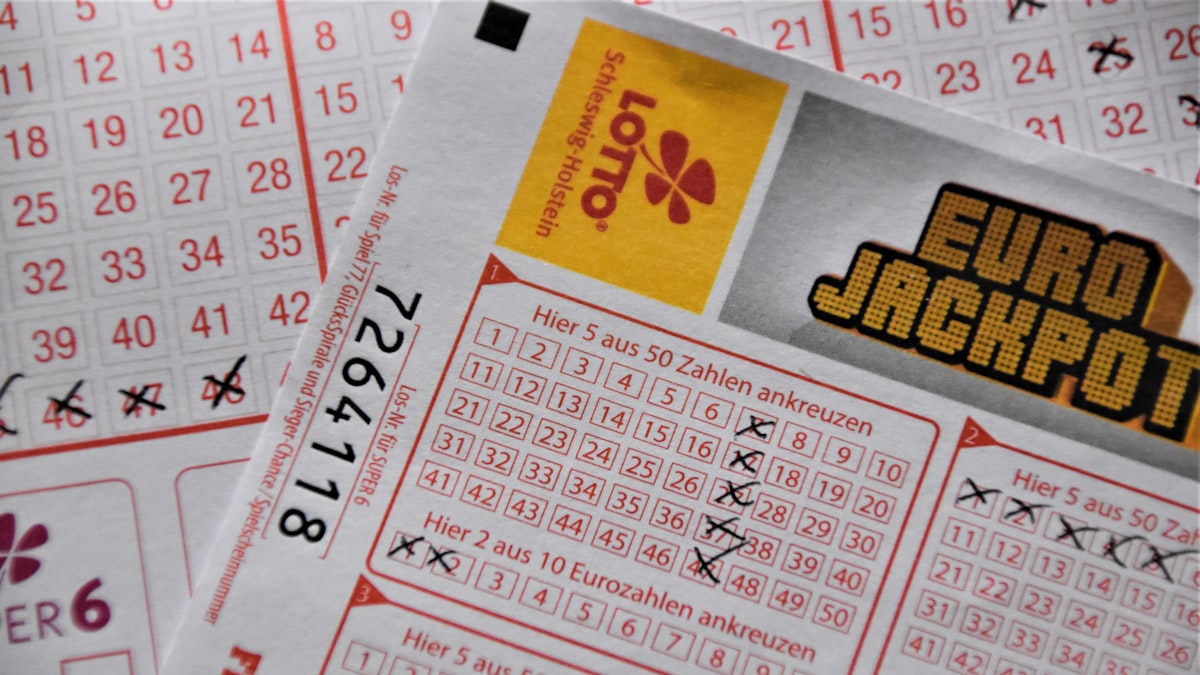 Cliente segurando bilhete de loteria enquanto aguarda no balcão da lotérica