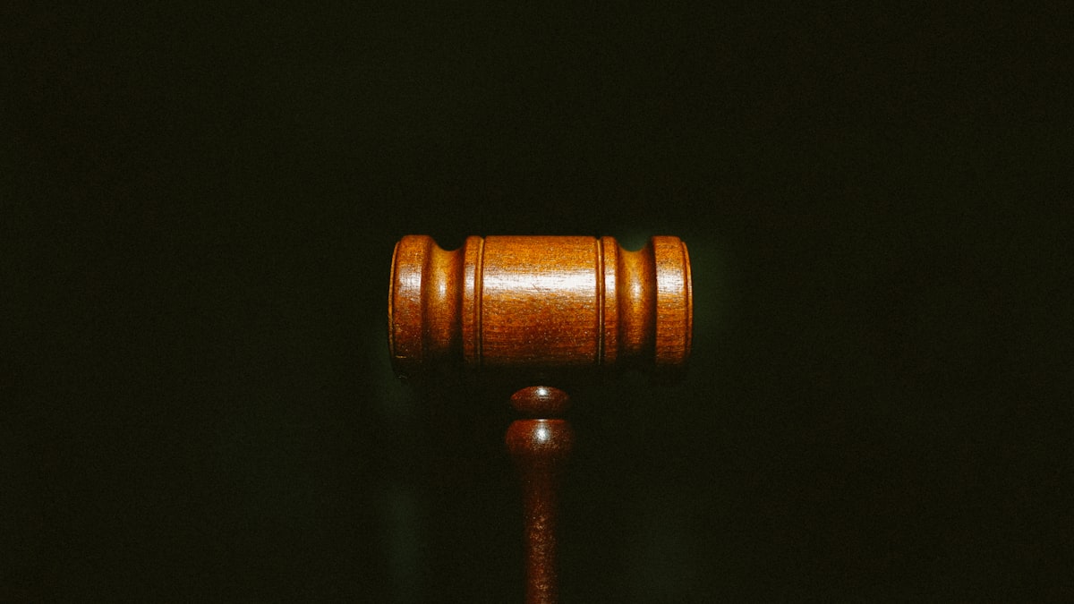 Martelo do juiz sobre a mesa do tribunal, simbolizando decisão judicial na esfera estadual