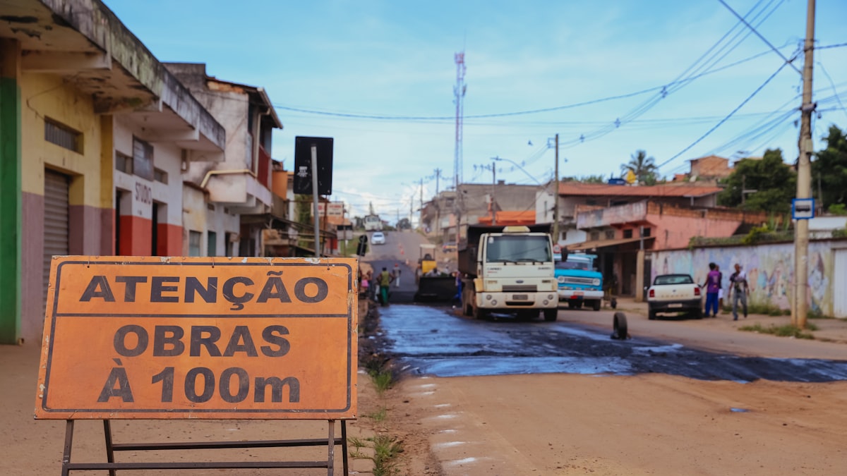 Rua arborizada e comércio local na Vila Valqueire RJ