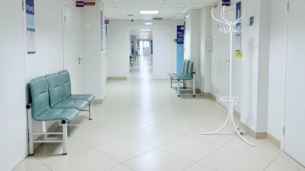 Profissionais de saúde caminhando em corredor hospitalar movimentado