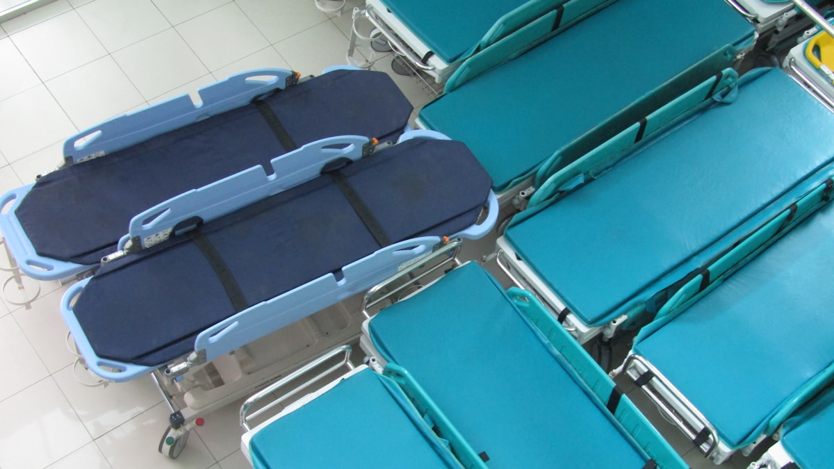 Equipe médica atende paciente em sala de emergência com monitores e respiradores