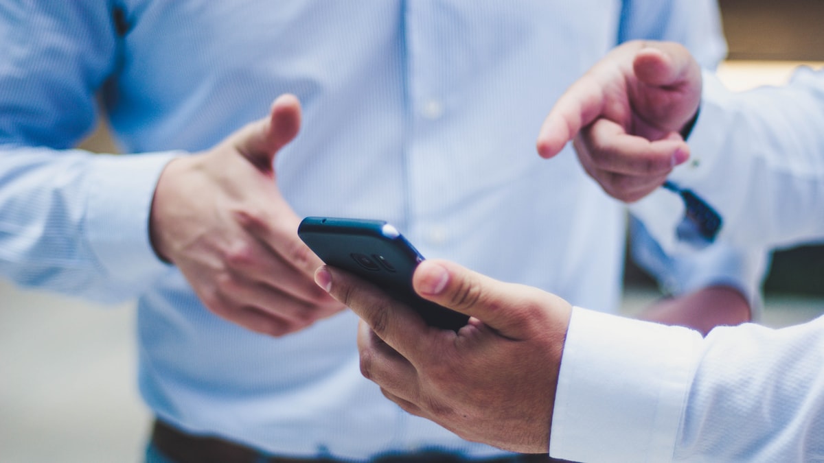 Perito analisando smartphone em laboratório com luvas e ferramentas