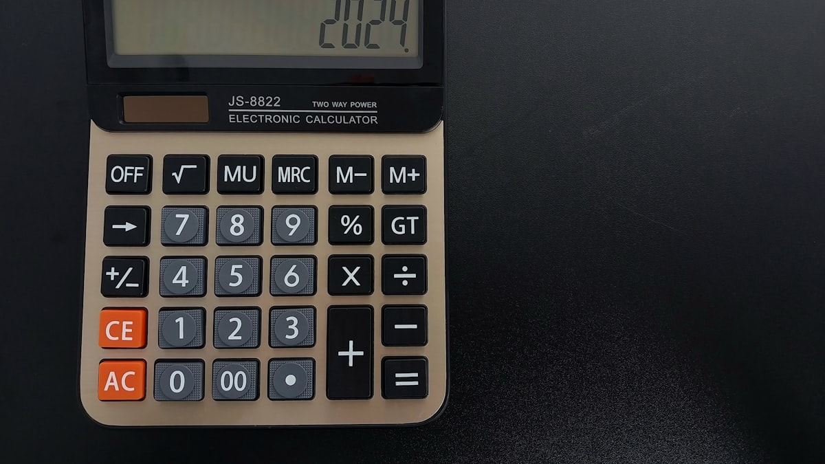 Calculadora ao lado de balança da justiça sobre relatório financeiro