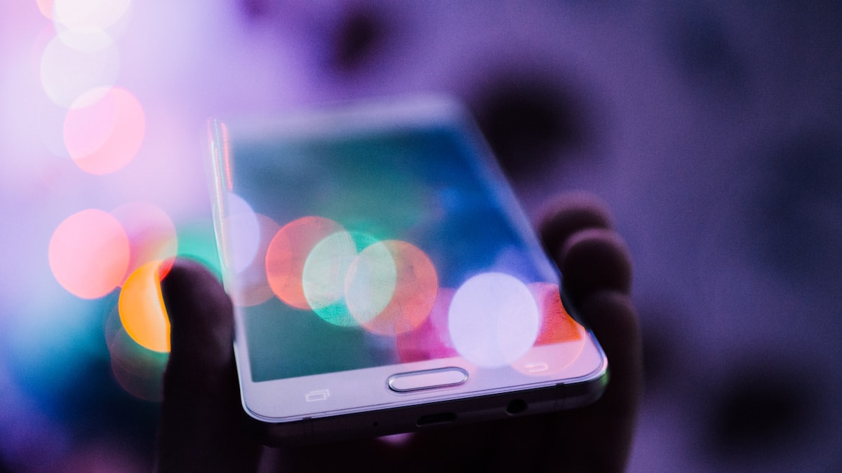 Pessoa organiza instruções póstumas em celular e caderno, com cadeado ao lado