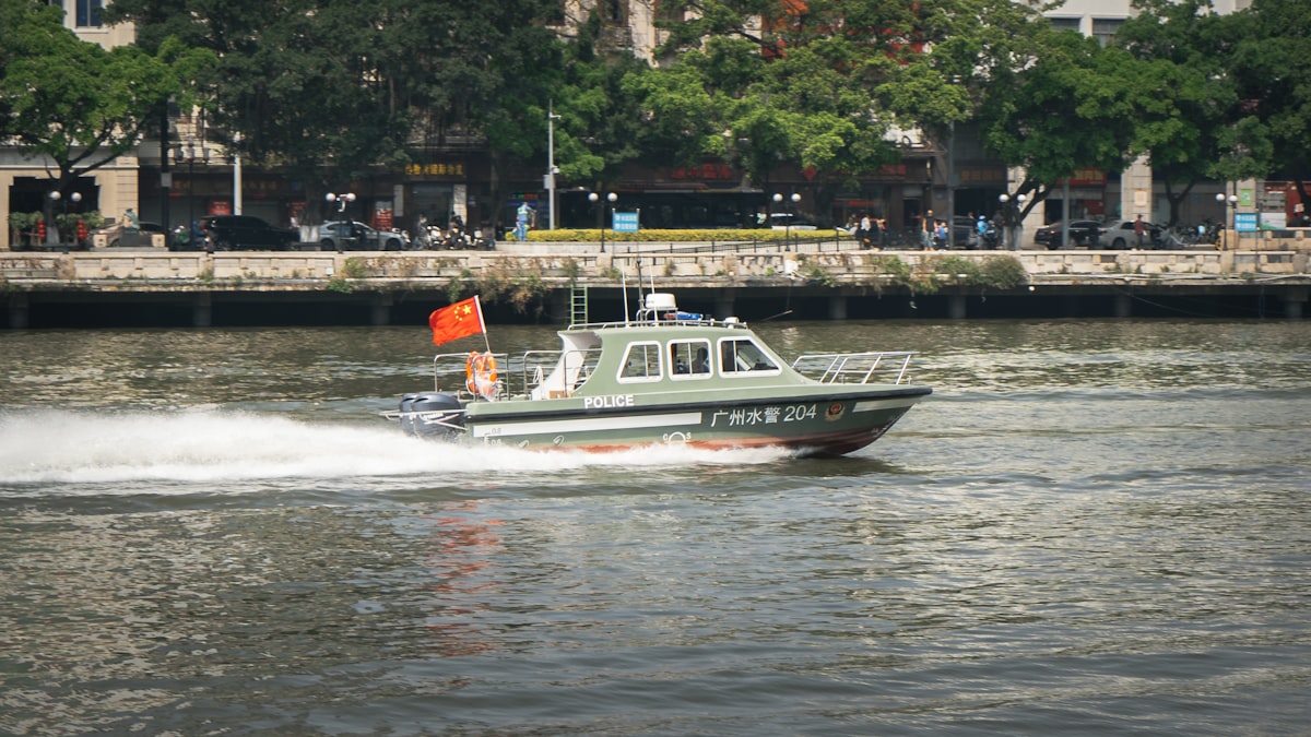 Agentes em barco fiscalizando rio de fronteira ao entardecer