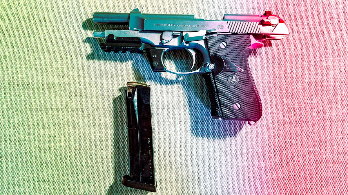 Perito analisa pistola e munições em bancada de laboratório forense