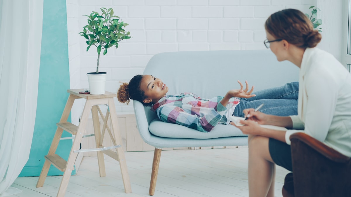 Psicóloga infantil conversa com criança em ambiente acolhedor do fórum