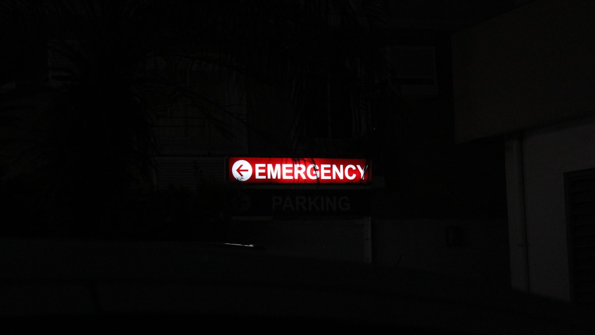 Entrada de pronto-socorro com ambulância e equipe médica em movimento