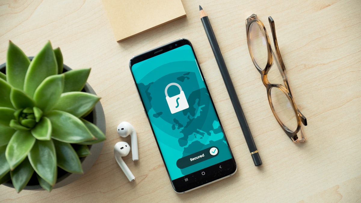 Pessoa segurando smartphone com mensagem de phishing suspeita na tela