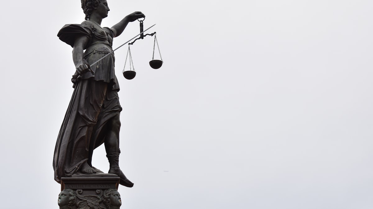 Balança da justiça ao lado de símbolo de família estilizada
