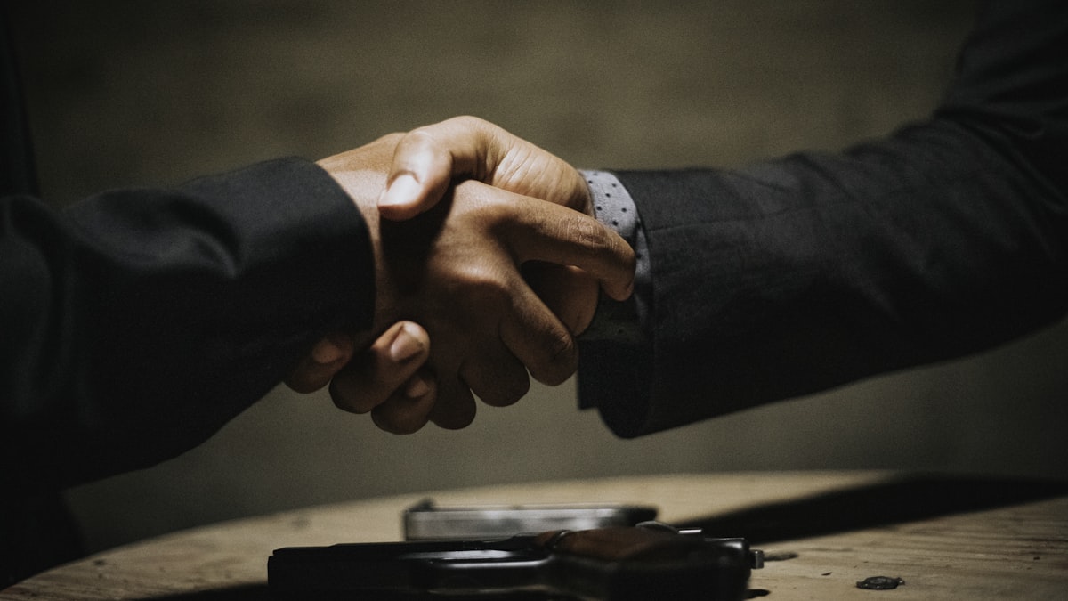 Duas pessoas apertando as mãos após acordo homologado em audiência