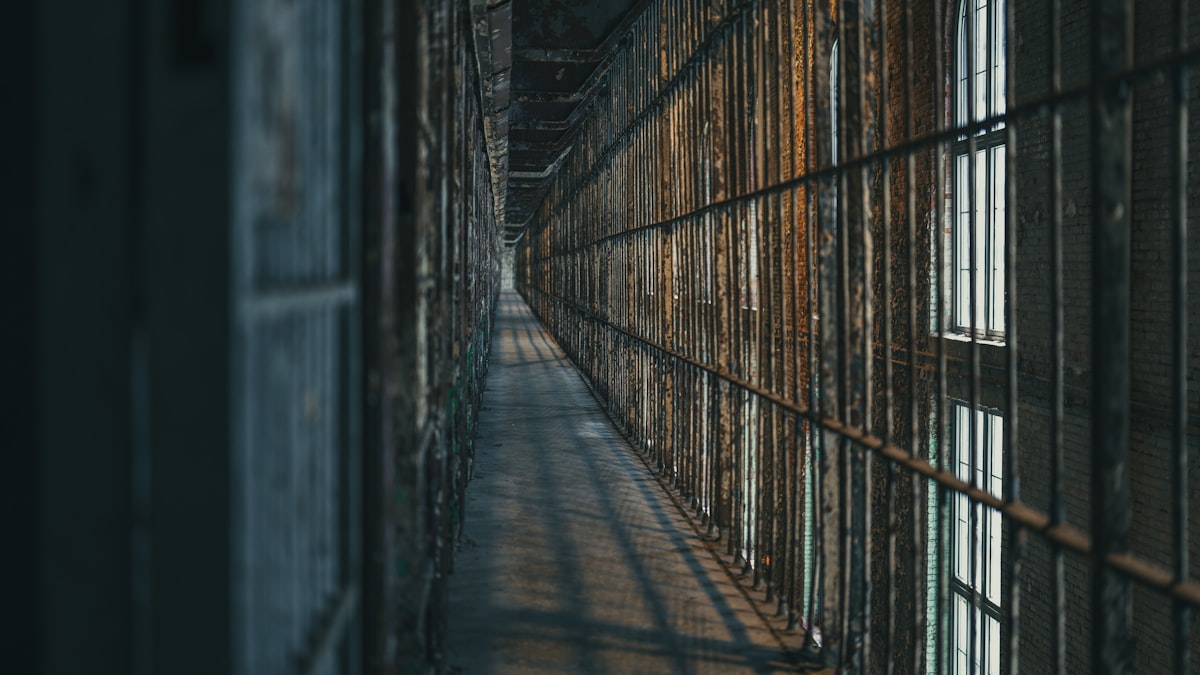Corredor de presídio com grades e iluminação fria