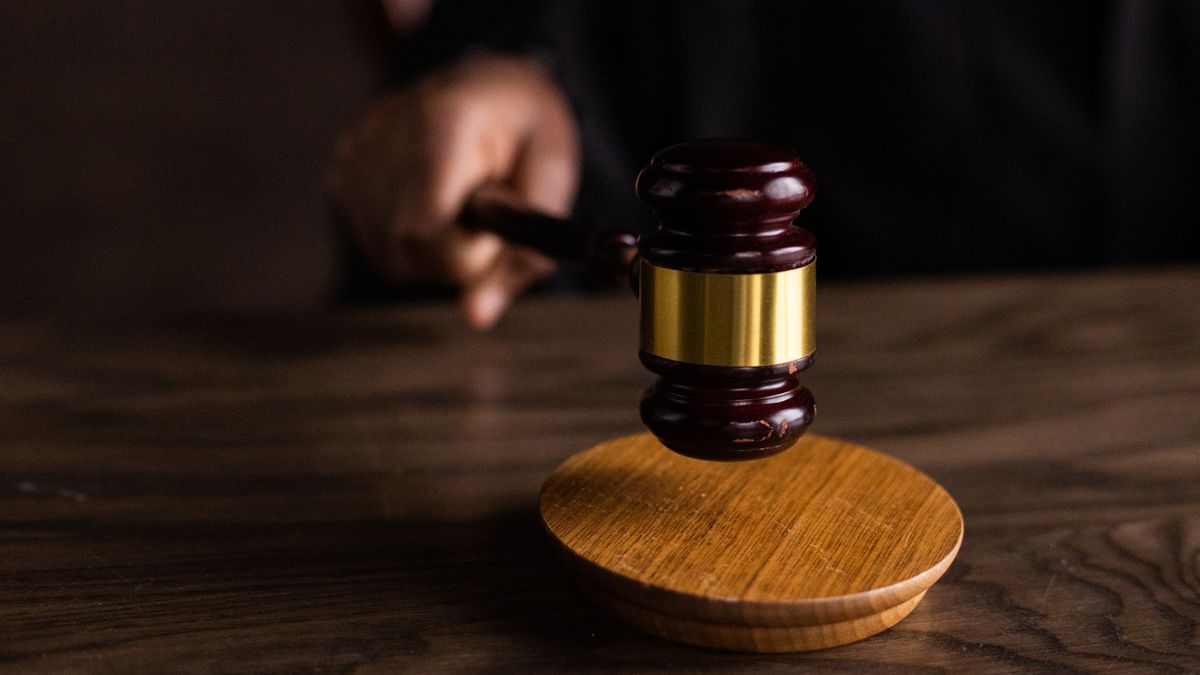 Martelo de juiz sobre mesa em tribunal durante audiência criminal