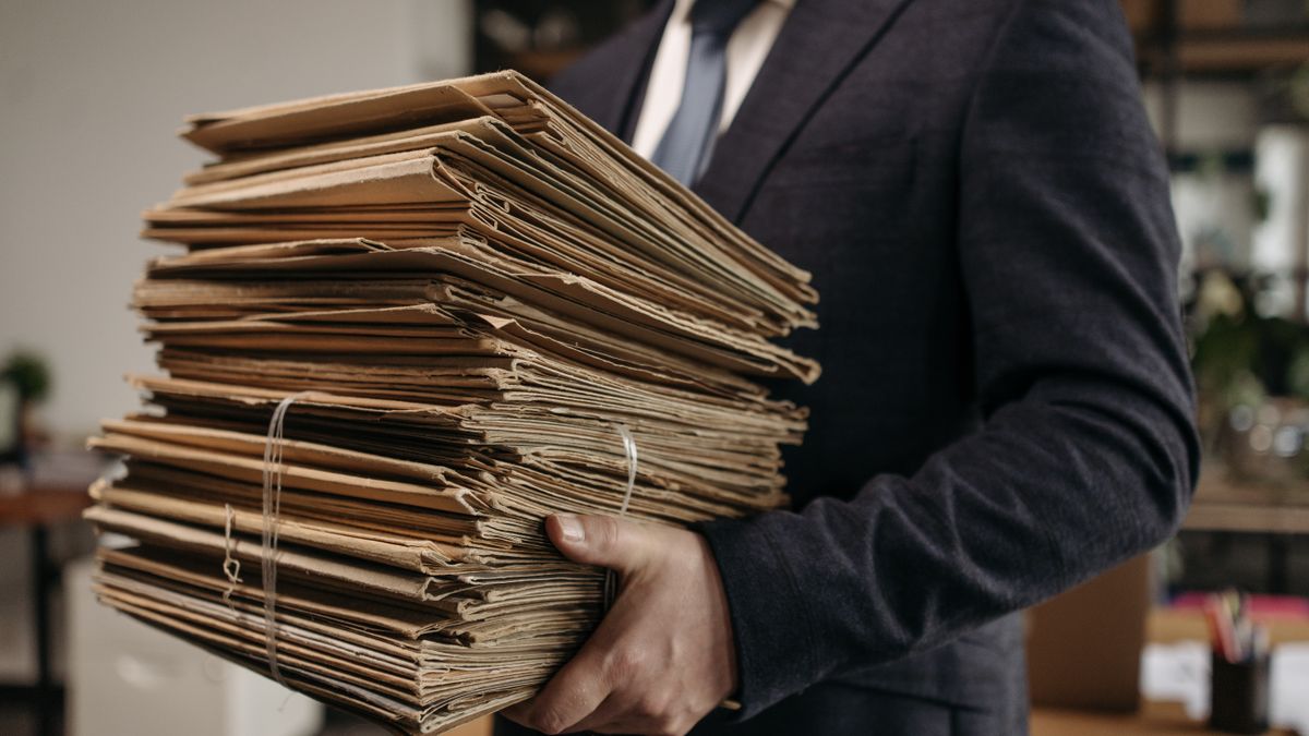 Pilhas de processos em prateleiras de um arquivo judicial lotado