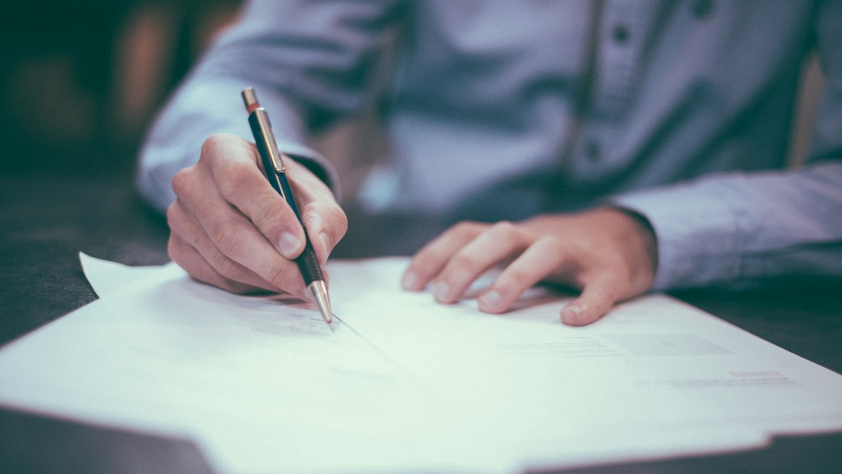 Herdeiros assinando escritura pública diante de tabelião atento