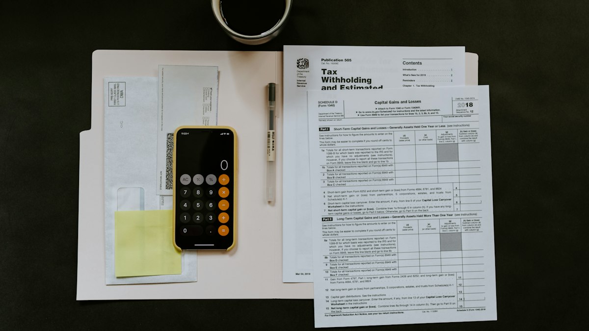 Planilha de imposto e calculadora ao lado de guias estaduais