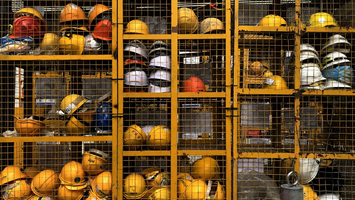 Operário utilizando EPI em área industrial com máquinas pesadas