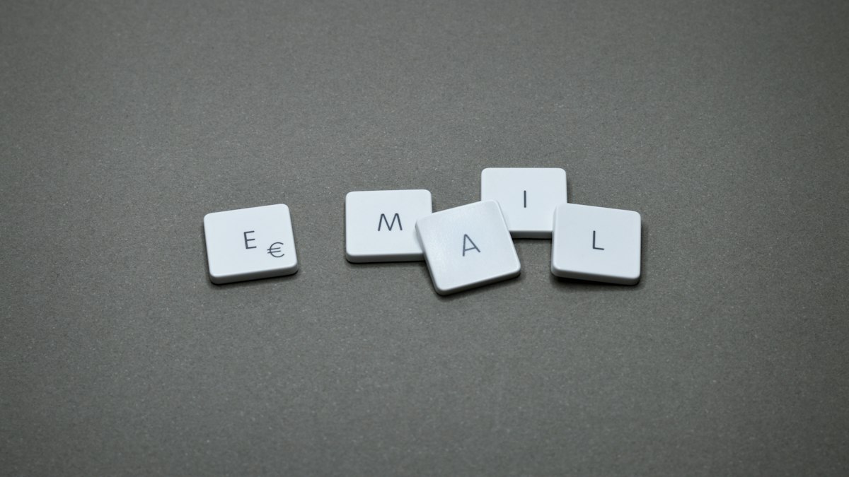 Duas pessoas trocando mensagens formais por e-mail em laptops
