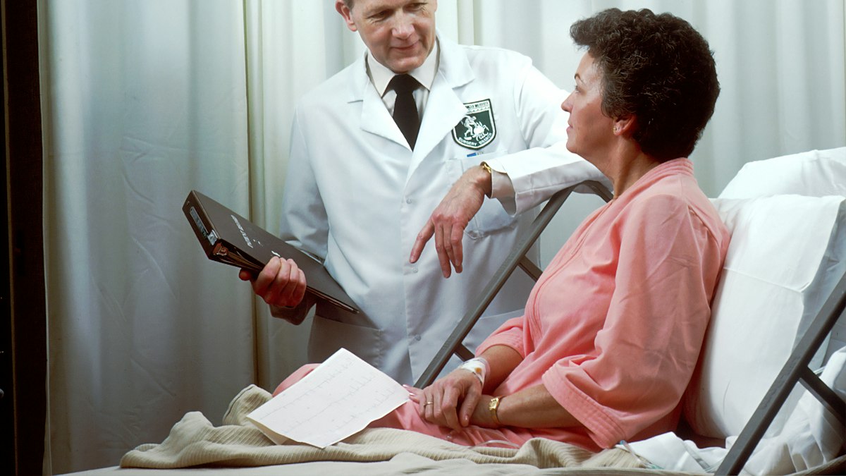 Médica e paciente analisam exames e plano de substituição de prótese