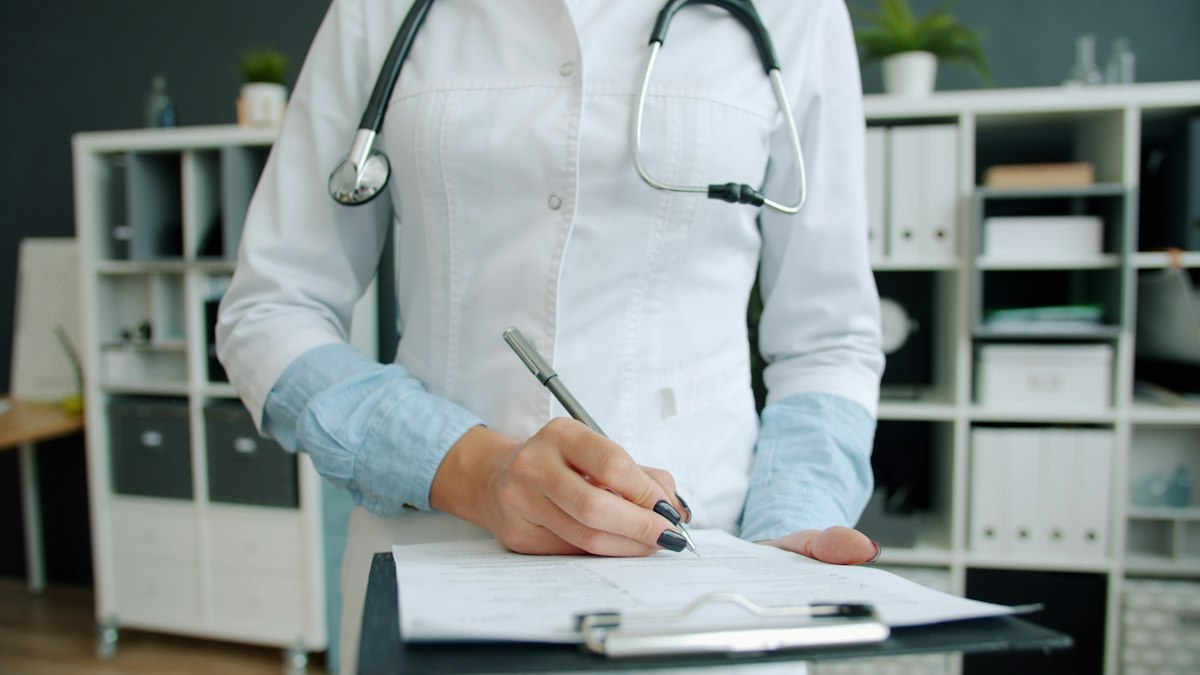 Médico preenchendo formulário de exame admissional em clínica pública