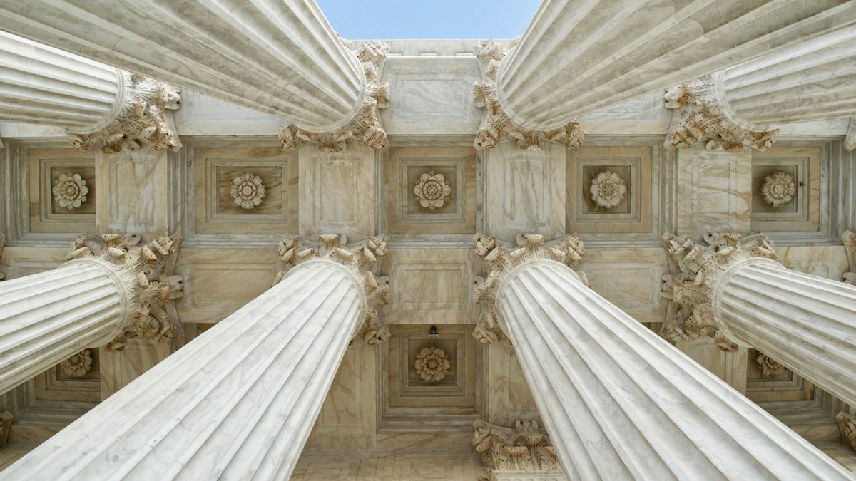 Fachada de tribunal com colunas monumentais ao entardecer
