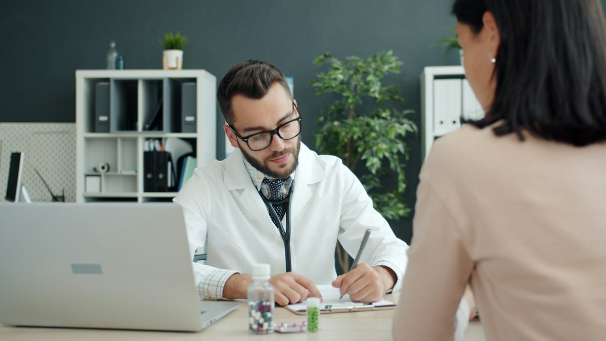 Médica analisando prontuário e exames com expressão atenta