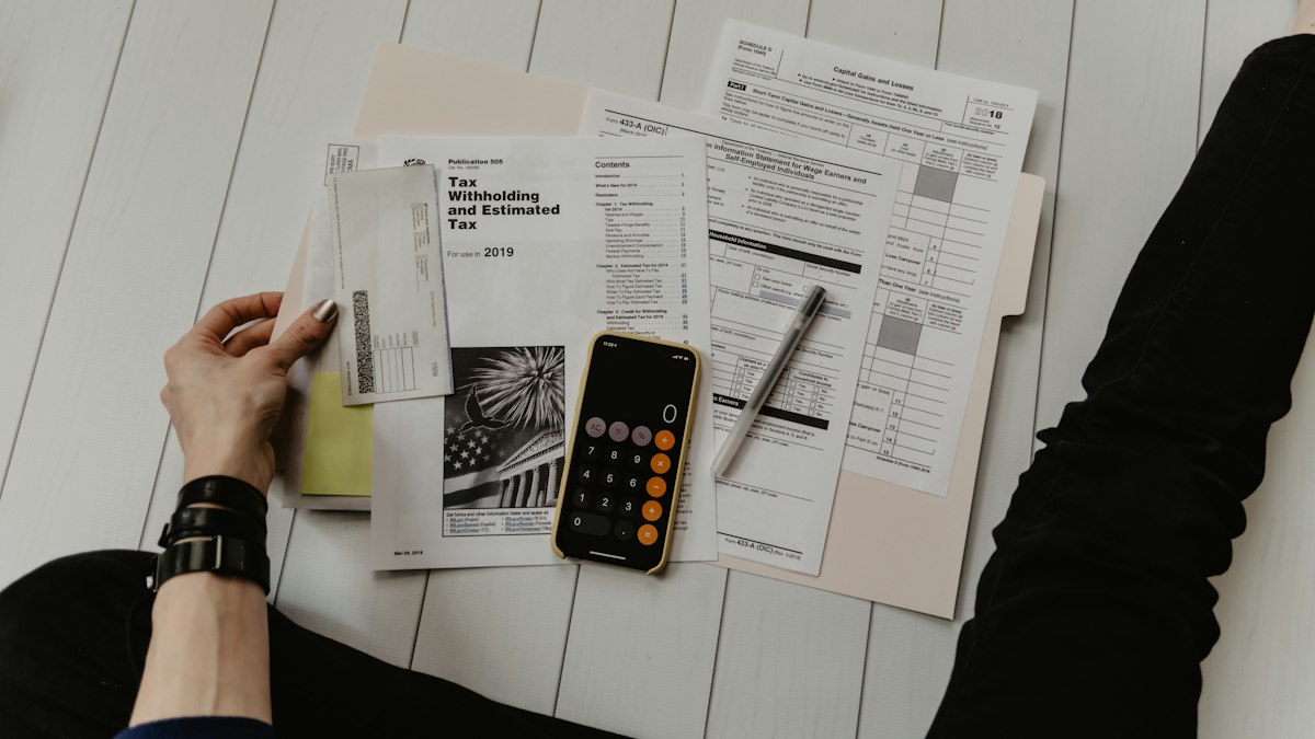 Pessoa analisando contas domésticas e orçamento familiar com calculadora