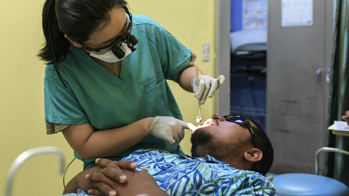 Médico militar realizando avaliação clínica de militar em consultório
